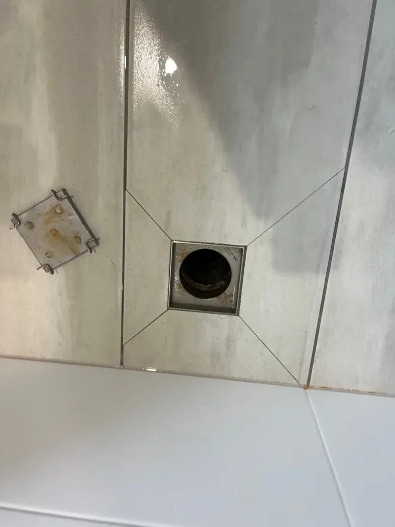 A tiled bathroom floor waste with the grate removed, ready for a drain camera