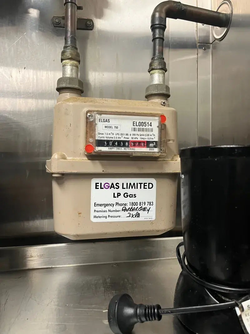 An LP gas meter and regulator installed in a commercial kitchen by a licensed gas fitter